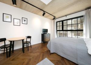 塔林Katla Maja Apartment的一间卧室配有一张床、一张桌子和一个窗户。