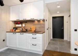 塔林Katla Maja Apartment的厨房配有白色橱柜和水槽