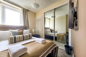 格拉斯哥No.5 Serviced Apartment的一间卧室配有一张带镜子的大床