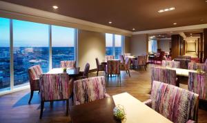 奥斯汀Fairmont Austin Gold Experience的餐厅设有桌椅和大窗户。