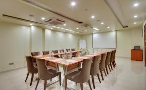 马累尤尼马格兰德酒店的大型会议室,配有长桌子和椅子