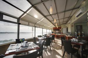 马累尤尼马格兰德酒店的餐厅设有桌椅和大窗户。