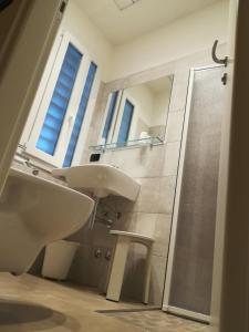 里米尼杜拉克酒店的一间带水槽、镜子和淋浴的浴室