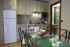 费尔莫塞列El Cobijo de los Arribes的厨房配有玻璃桌和白色冰箱。