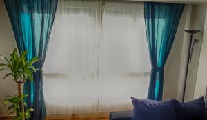 希洪La Casa de Alba的客厅设有大窗户和蓝色窗帘