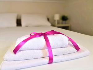 诺瓦利娅Villa Gaj的床上的带粉红色丝带的毛巾