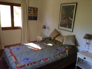 Monte GrandeCasa Higuera en MonteGrande的一间卧室,床上有五颜六色的被子