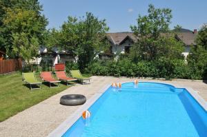 Dorfstetten安革若夫酒店的一个带椅子的庭院和房子的游泳池