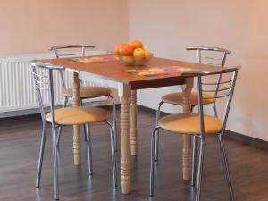 特鲁斯卡韦茨Sweet Apartment的一张带四把椅子的木桌和一碗水果
