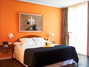 马亚达洪达美亚里哈达酒店的一间卧室配有一张橙色墙壁的床