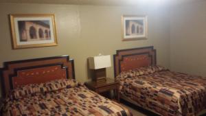 InteriorBadlands Hotel & Campground的酒店客房设有两张床,墙上挂有绘画作品