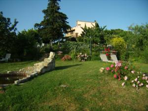 蒙泰斯佩尔托利B&B Il Poggetto的草上种着长凳和花的公园