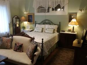 尼亚加拉瀑布Hanover House Bed and Breakfast的一间卧室配有一张带椅子和沙发的床