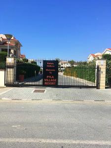 皮拉Pyla Village Resort F110 (Apartment near Larnaca)的房屋前的栅栏上的一个标志