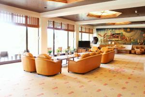 宫岛宫岛海边酒店 的大型客厅配有橙色椅子和电视