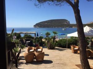 阿尔盖罗Villa Margherita的一个带椅子的庭院,享有海滩美景