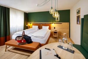 维尔德豪斯Hotel Hirschen Wildhaus的酒店客房带一张床、一张桌子和椅子