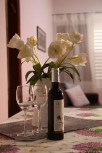 Neot GolanKinneret Guesthouse的一瓶葡萄酒和两杯带鲜花的桌子