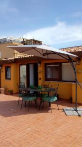 陶尔米纳Attico Sole Luna的庭院配有桌椅和遮阳伞。