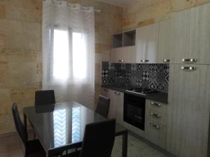 博尔加涅Appartamenti turistici Aprile Luca的厨房配有桌椅和窗户。