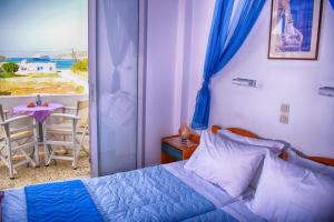 伊奥斯乔拉海伦娜旅馆的一间卧室配有一张床,享有海滩美景