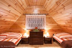 达尔沃沃Domki letniskowe IWET的小木屋卧室内的两张床,配有两盏灯