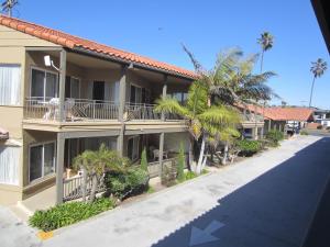 圣地亚哥太平洋海岸酒店 的街道前方有棕榈树的建筑