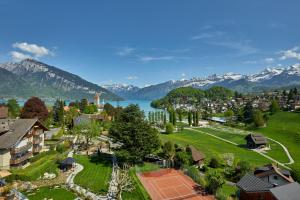 施皮茨Hotel Eden Spiez的享有湖泊和山脉小镇的空中景致