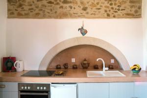 PotamósThe Stone House的厨房配有带砖炉的台面