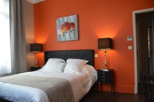 佩里格Villa Vesone的一间卧室设有橙色墙壁和一张带两盏灯的床。
