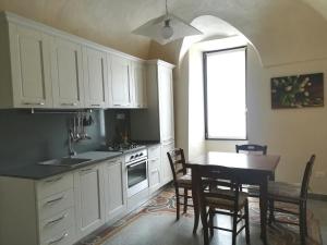 多尔切阿夸BeB I Girasoli的厨房配有白色橱柜和桌椅