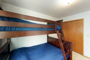 哥德伍德Snowbird 131-B的一间卧室配有两张双层床,铺有蓝色床单。