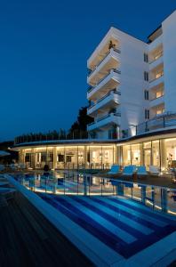 马里纳-迪-皮特拉桑塔蒙迪艾尔度假温泉酒店的大楼前设有游泳池的酒店