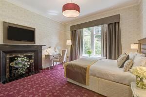 鲍内斯温德米尔力推本豪花园大厦酒店的酒店客房配有一张床和一个壁炉。