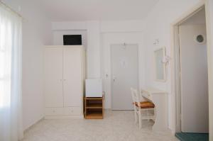 伊奥斯乔拉Athena Rooms的白色的客房配有书桌和白色的墙壁