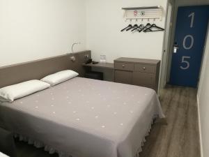 巴塞罗那诺坎普阿尔格尔酒店 的卧室配有一张白色大床和一张书桌