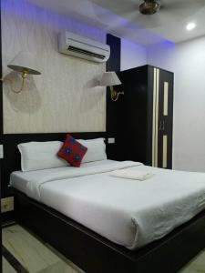阿格拉Hotel Laxman Resort by The Golden Taj Group &Hotels的一间卧室配有一张大床和黑色床头板