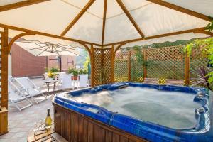 圣费利切德尔贝纳科Barchi Resort - Apartments & Suites的庭院内的热水浴池和遮阳伞