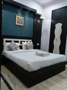 阿格拉Hotel Laxman Resort by The Golden Taj Group &Hotels的一间卧室设有一张蓝色墙壁的大床