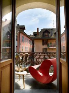 安锡独特乐杜公寓的阳台顶部的红色椅子