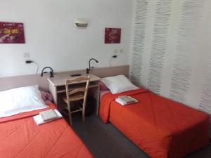 皮埃尔菲特－内斯塔拉游客酒店的配有书桌和四柱床的客房内的两张床