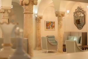 突尼斯Dar El Jeld Hotel and Spa的一间设有圆柱和椅子的房间,墙上有一幅画