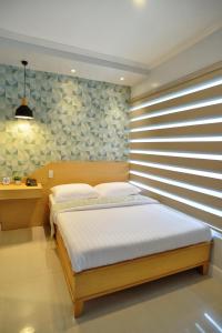 Daet达特福尔摩萨酒店的一间卧室配有一张带木制床头板的床