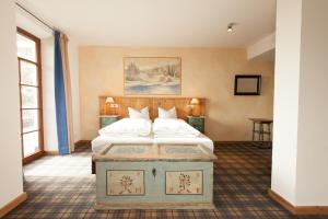 施坦贝尔格湖畔贝格奥夫基辛POST酒店的卧室配有带白色枕头的大床