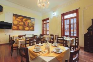波哥大圣露西亚精品温泉酒店的餐厅设有桌椅,墙上挂有绘画作品