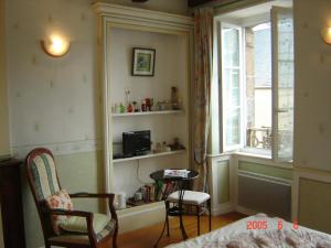 格朗维尔Le Logis du Roc的客房设有床、桌子和窗户。