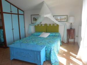 卡波利韦里Villatramontistella的一间卧室配有一张带天蓬的蓝色床