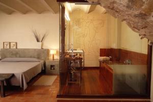 马德雷马尼亚拉普拉卡马德雷马尼亚酒店的一间卧室设有一张床和一个玻璃淋浴间
