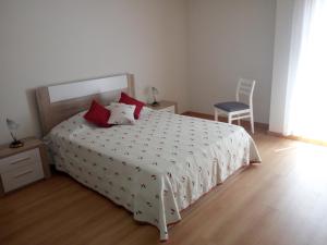 奥良Fun & Sun Apartment的卧室配有白色的床、红色枕头和椅子