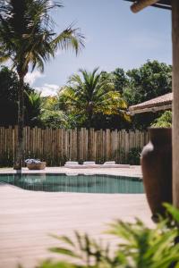 卡拉伊瓦Villa Fulô的一座拥有棕榈树和木栅栏的游泳池